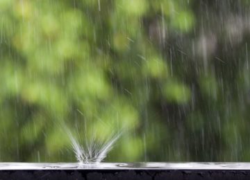 imagem de uma gota de chuva atingindo o beiral de uma janela